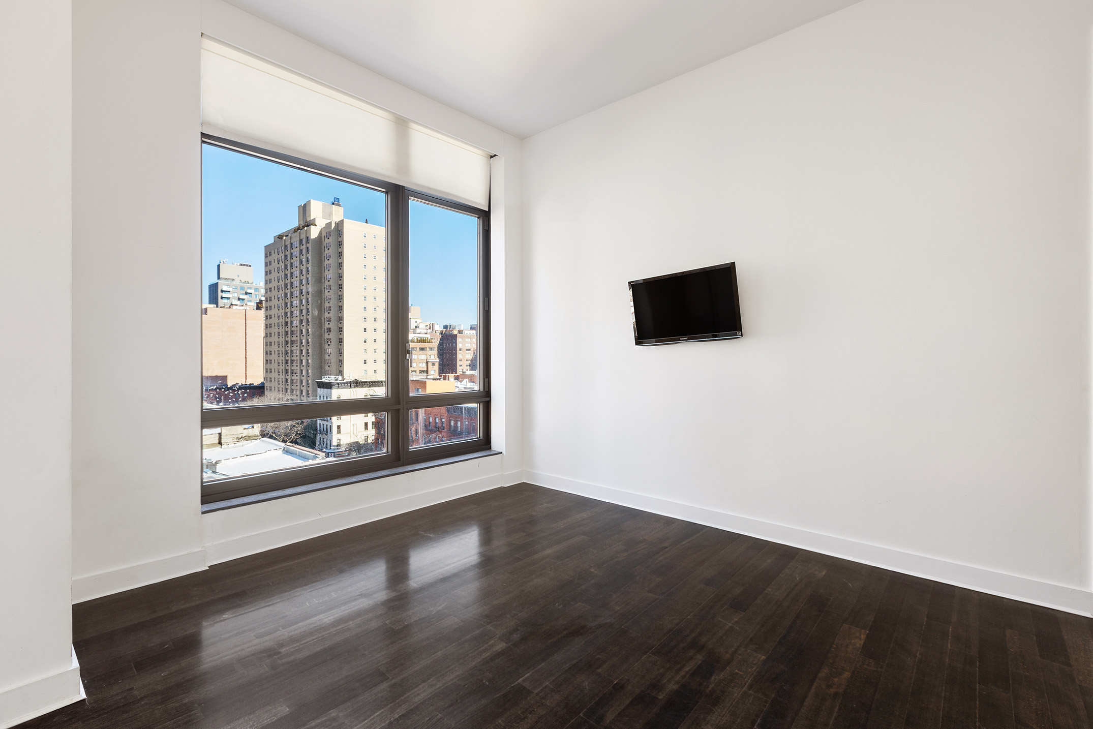 450 East 83rd Street, Unit 8B Manhattan, NY 10028 - Photo 11 of 22 an empty room with wooden floor and windows