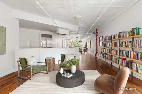 a living room with furniture and a book shelf
