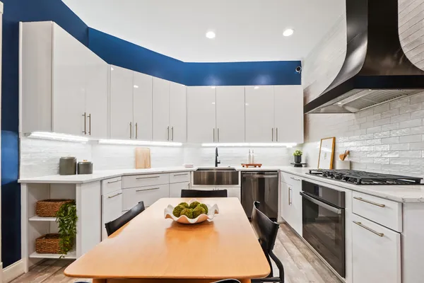 a kitchen with kitchen island granite countertop a sink stainless steel appliances and cabinets