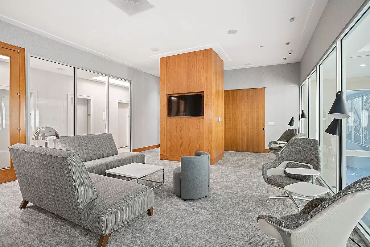 20 West Street, Unit 31C Manhattan, NY 10004 - Photo 10 of 16 a living room with furniture and a window