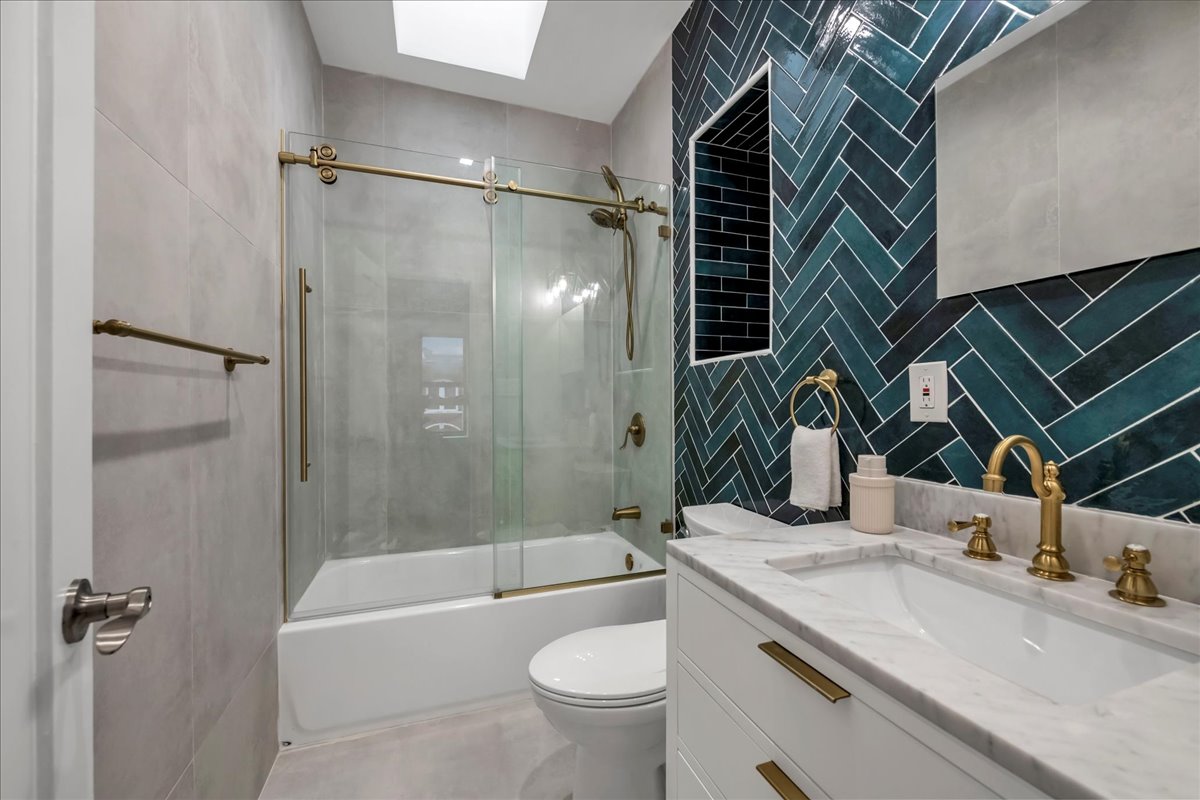 448 Halsey Street, Unit 1 Brooklyn, NY 11233 - Photo 18 of 22 a bathroom with a granite countertop sink toilet and shower