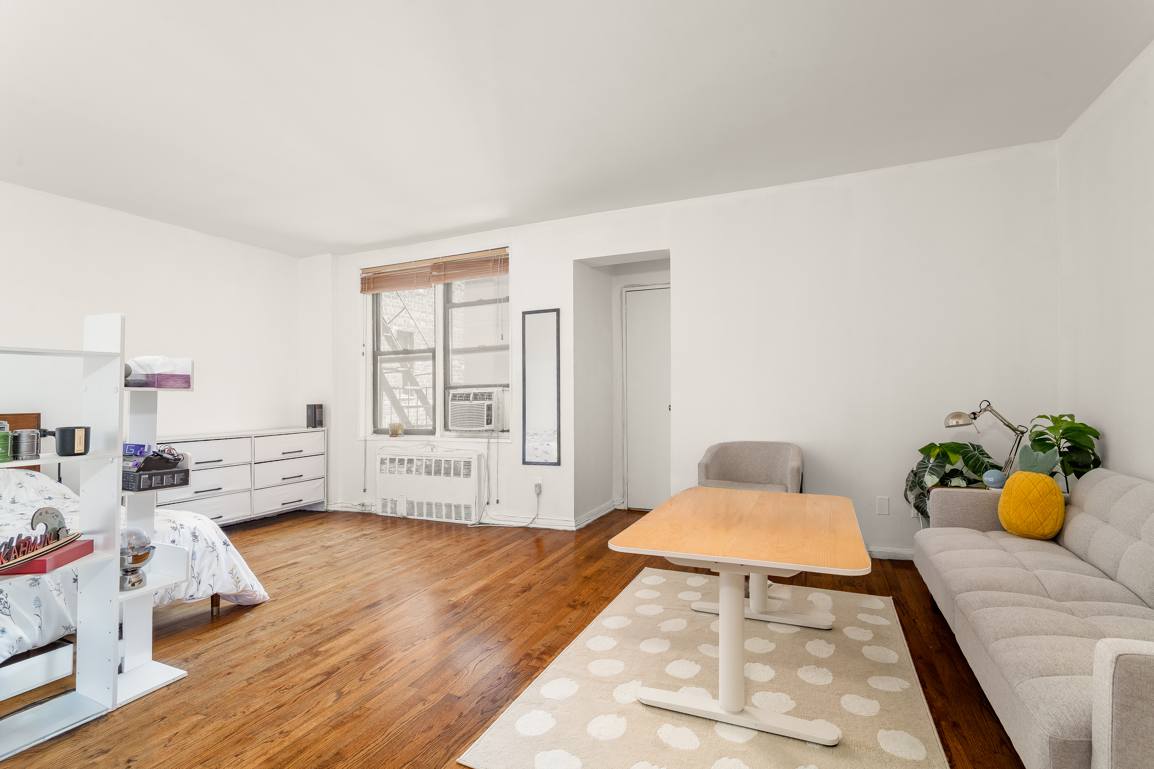 1420 York Avenue, Unit 6J Manhattan, NY 10021 - Photo 2 of 13 a bedroom with furniture and a wooden floor
