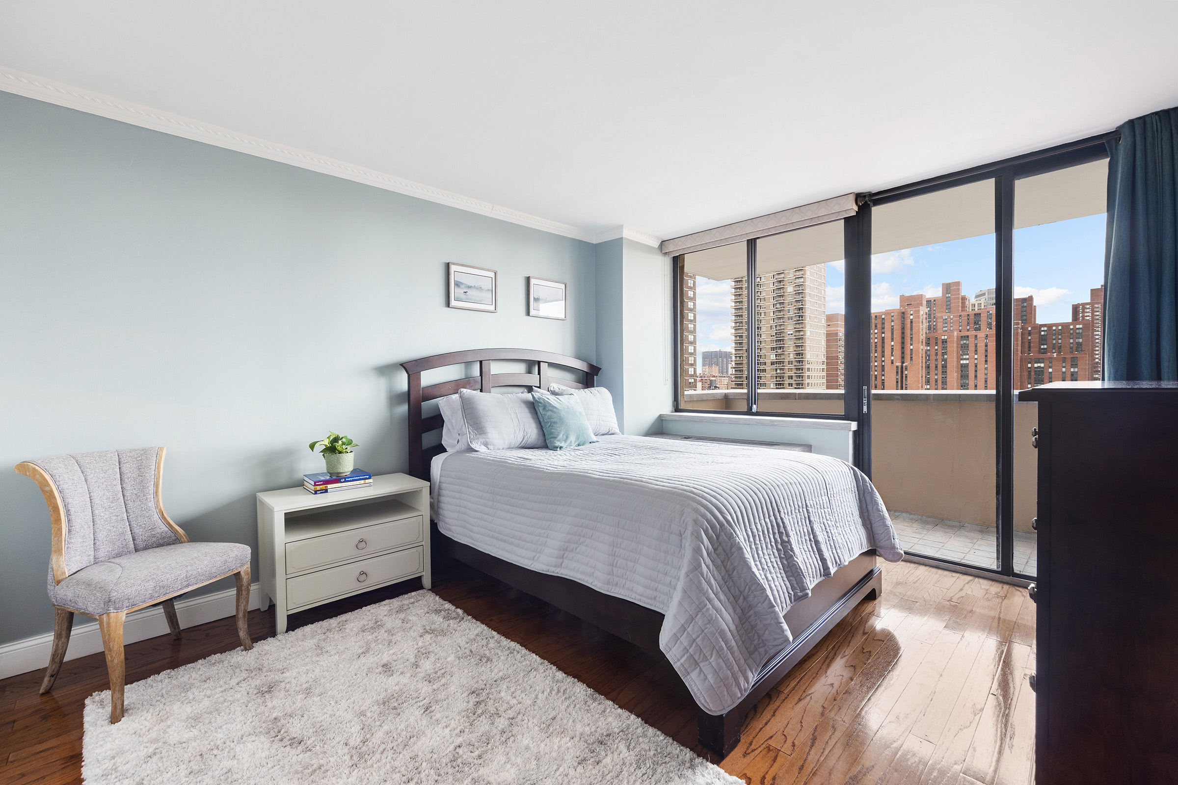 233 East 86th Street, Unit PHB Manhattan, NY 10028 - Photo 6 of 12 a bedroom with a bed lamp and a large window
