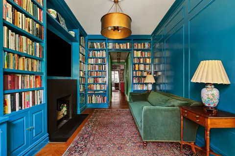 a living room with fish tank and a bookshelf