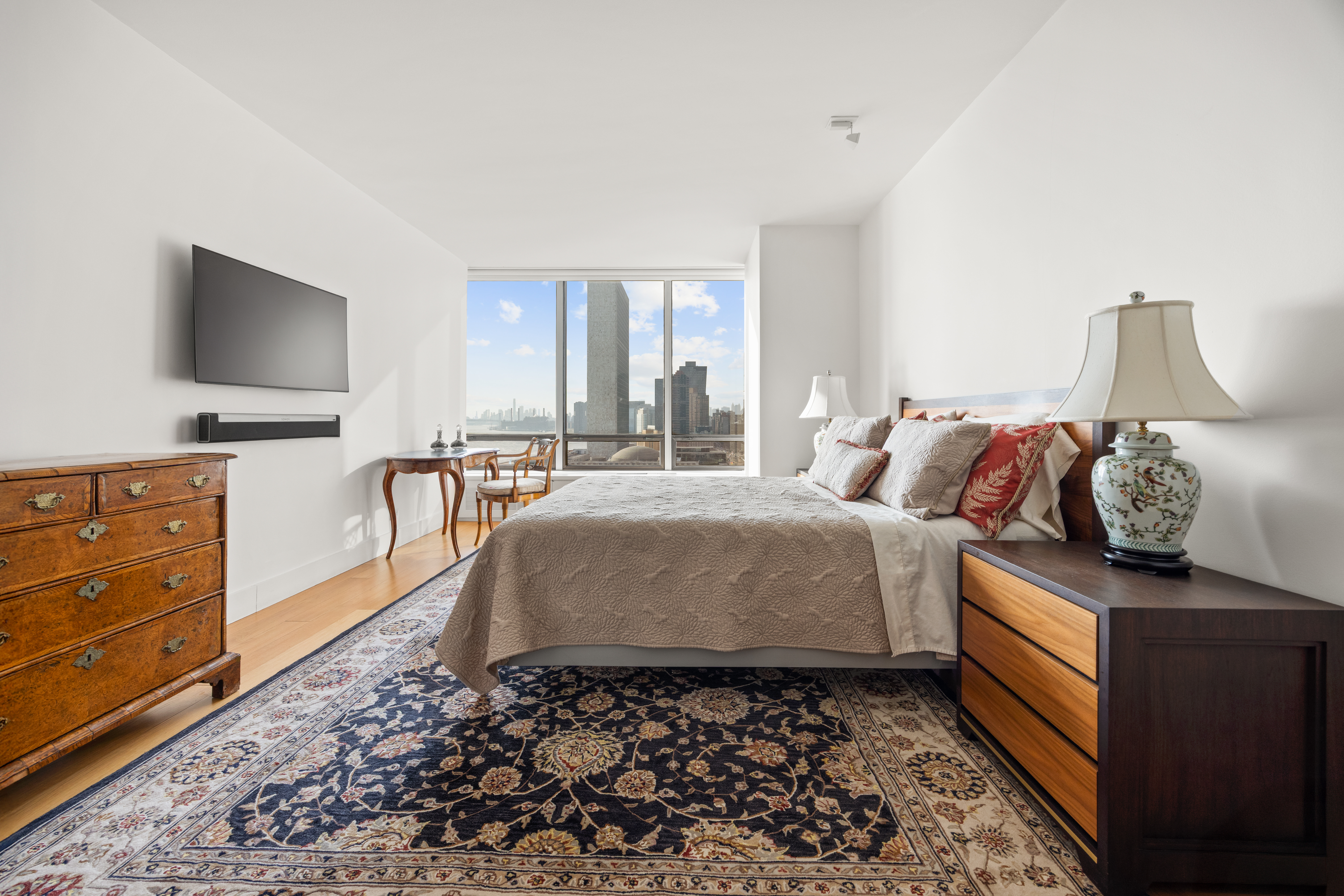 860 United Nations Plaza, Unit 16G Manhattan, NY 10017 - Photo 8 of 12 a bedroom with a bed and flat screen tv