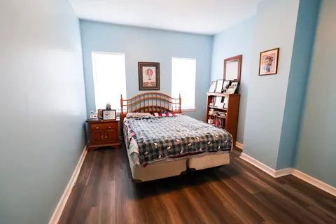 a bedroom with a bed and wooden floor