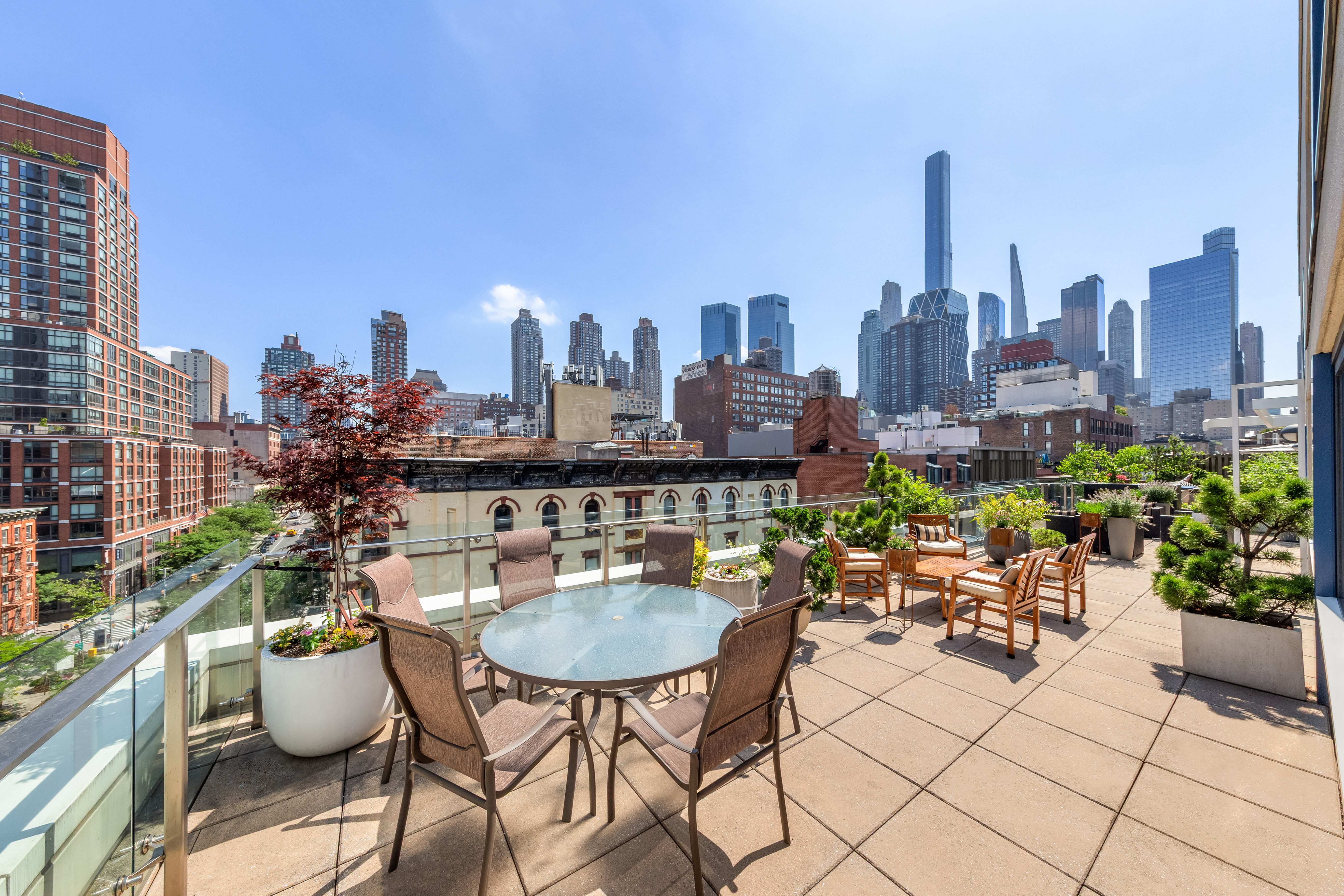 454 West 54th Street, Unit 7B Manhattan, NY 10019 - Photo 11 of 15 a table and chairs in front of the city view