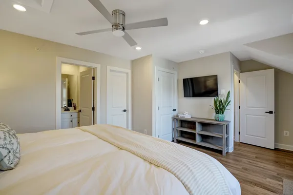 a bedroom with a bed and a flat tv screen on wall