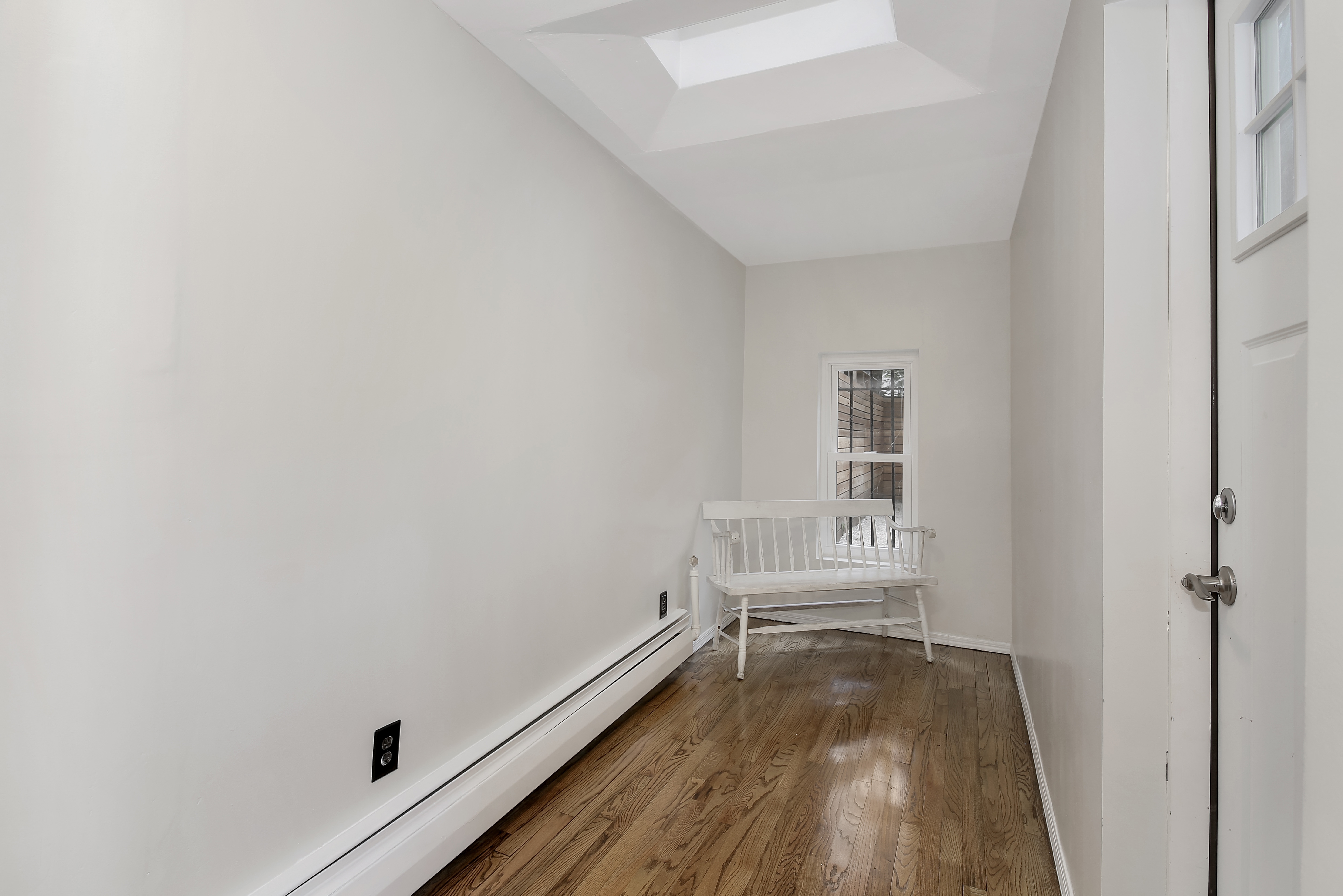 666 Putnam Avenue, Unit 1 Brooklyn, NY 11221 - Photo 5 of 8 a view of a room with wooden floor and white walls