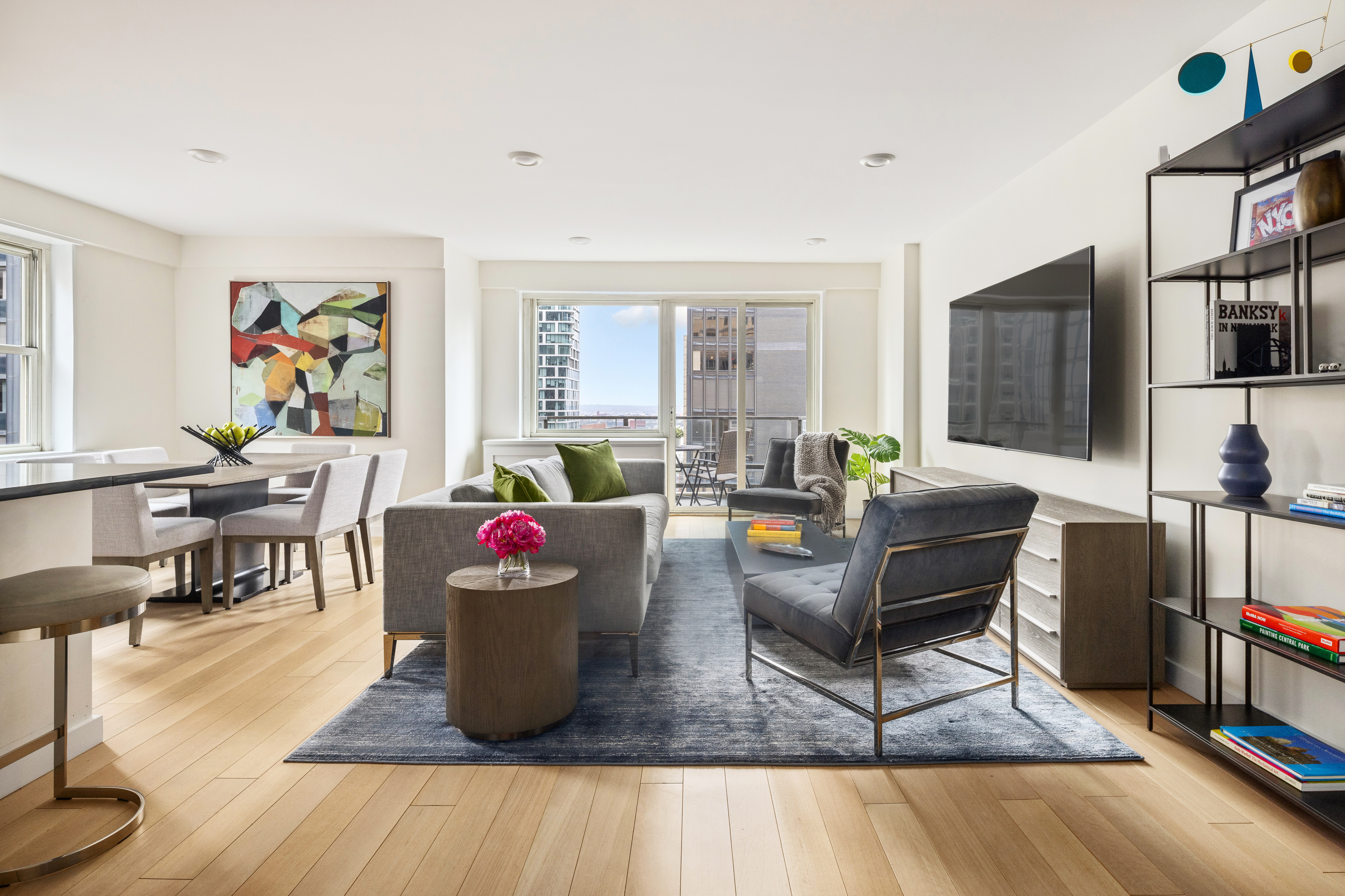 159 West 53rd Street, Unit 34E Manhattan, NY 10019 - Photo 2 of 15 a living room with furniture and a flat screen tv