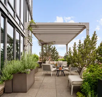 a patio with a table and chairs and potted plants