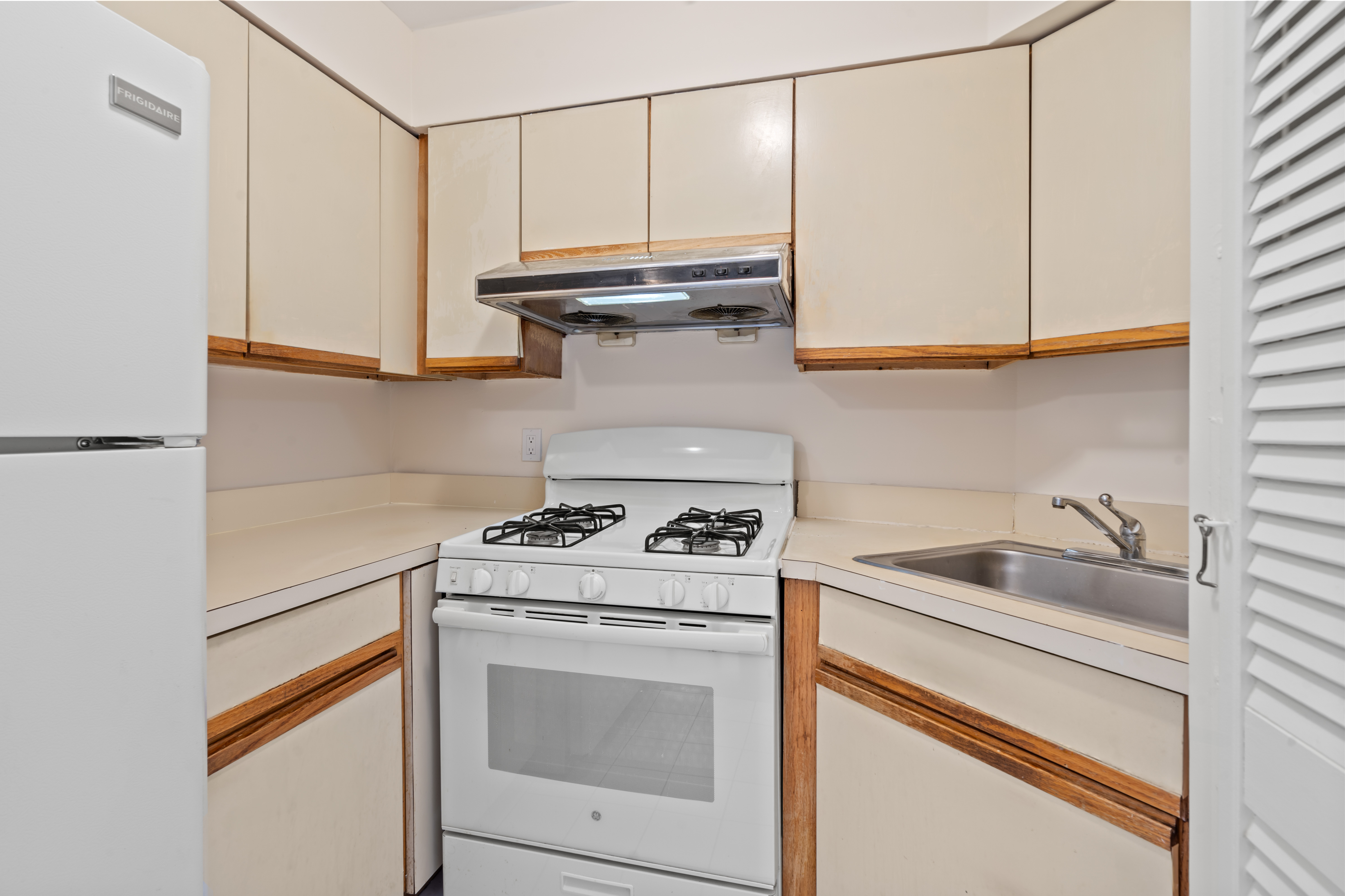 37-30 103rd Street, Unit 2E Queens, NY 11368 - Photo 3 of 8 a kitchen with white cabinets and white appliances