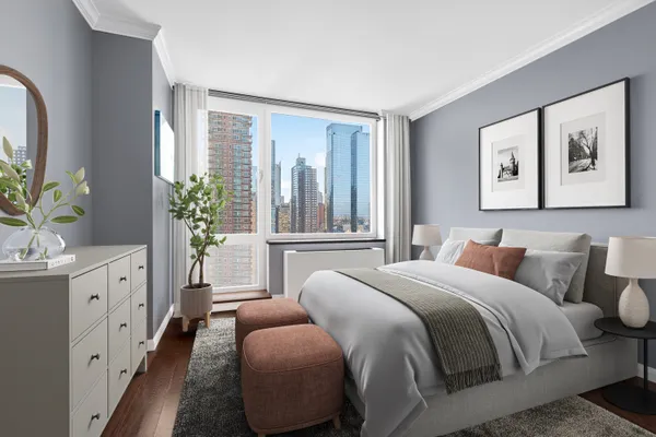 a bedroom with a large bed and a potted plant