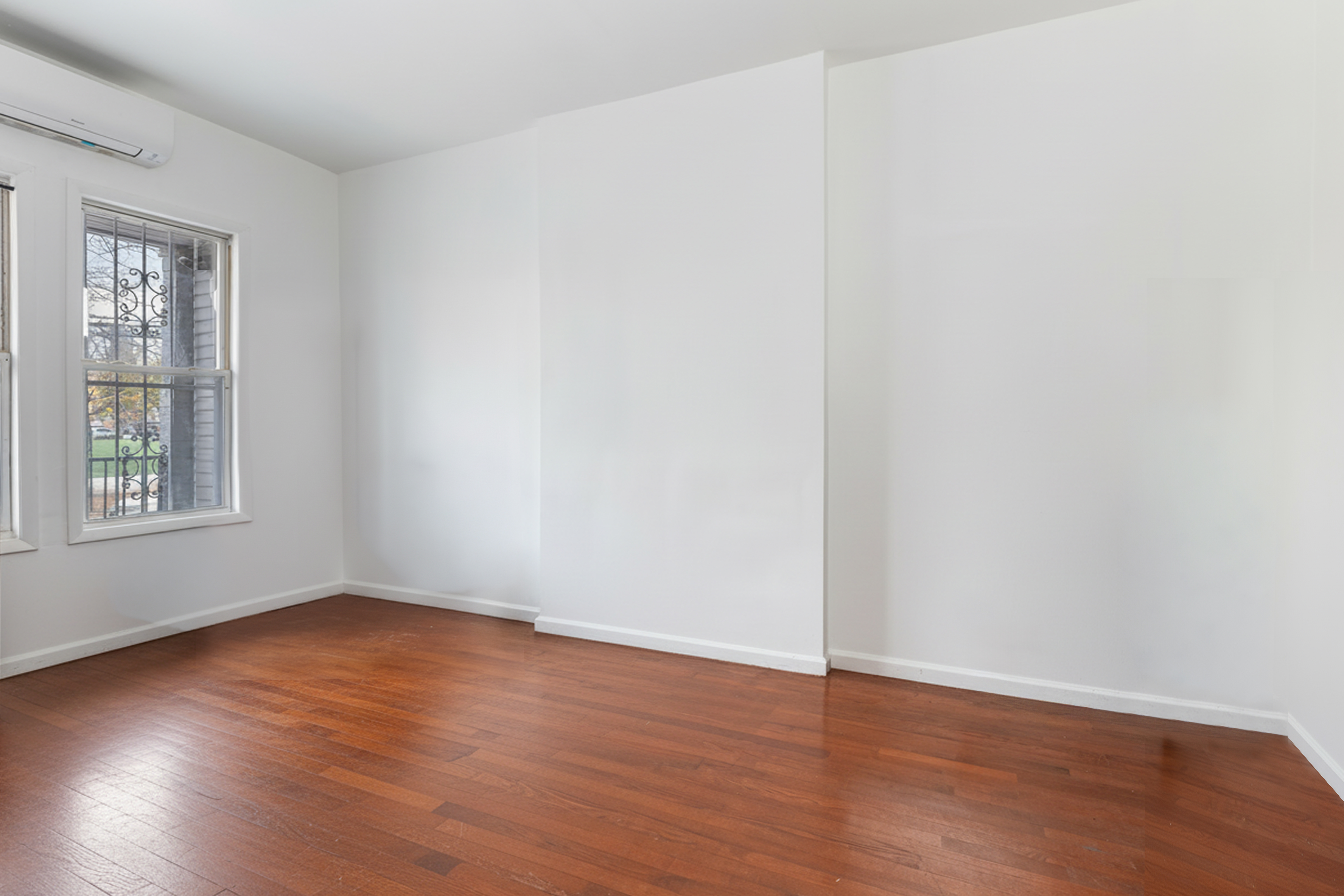 610 East 181st Street Bronx, NY 10457 - Photo 4 of 13 a view of an empty room with wooden floor and a window
