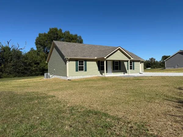 a front view of a house with yard and green space