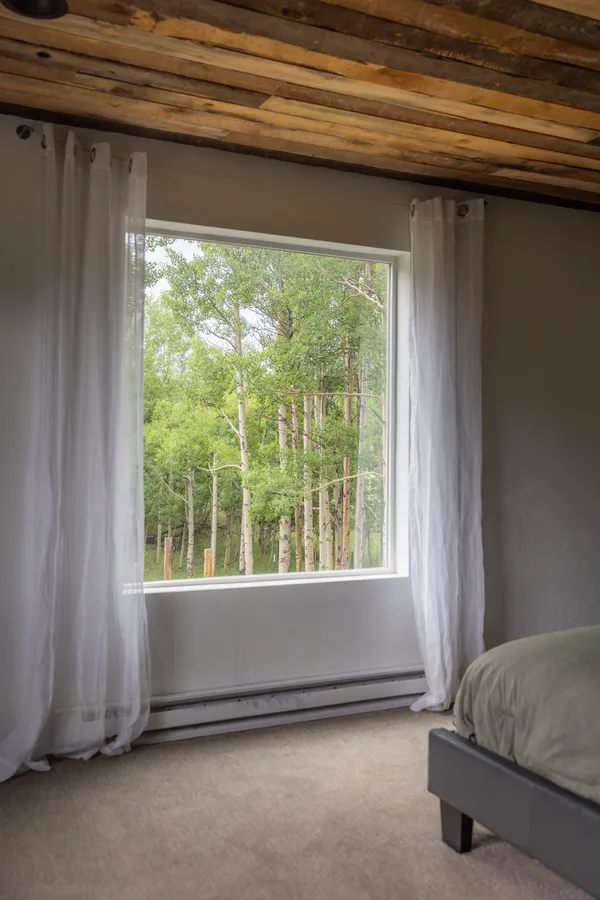 a living room with a bed and a window