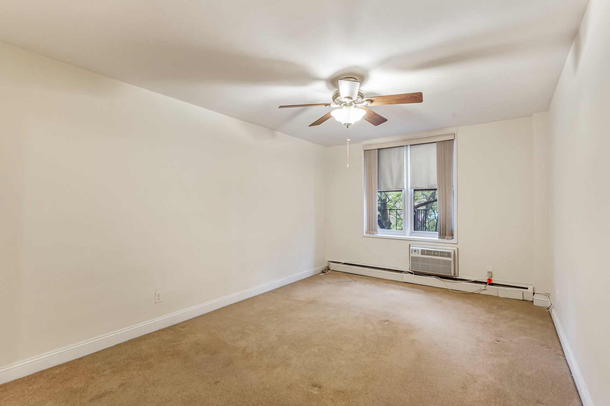 54-44 Little Neck Parkway, Unit 5G Queens, NY 11362 - Photo 11 of 20 an empty room with windows and ceiling fan