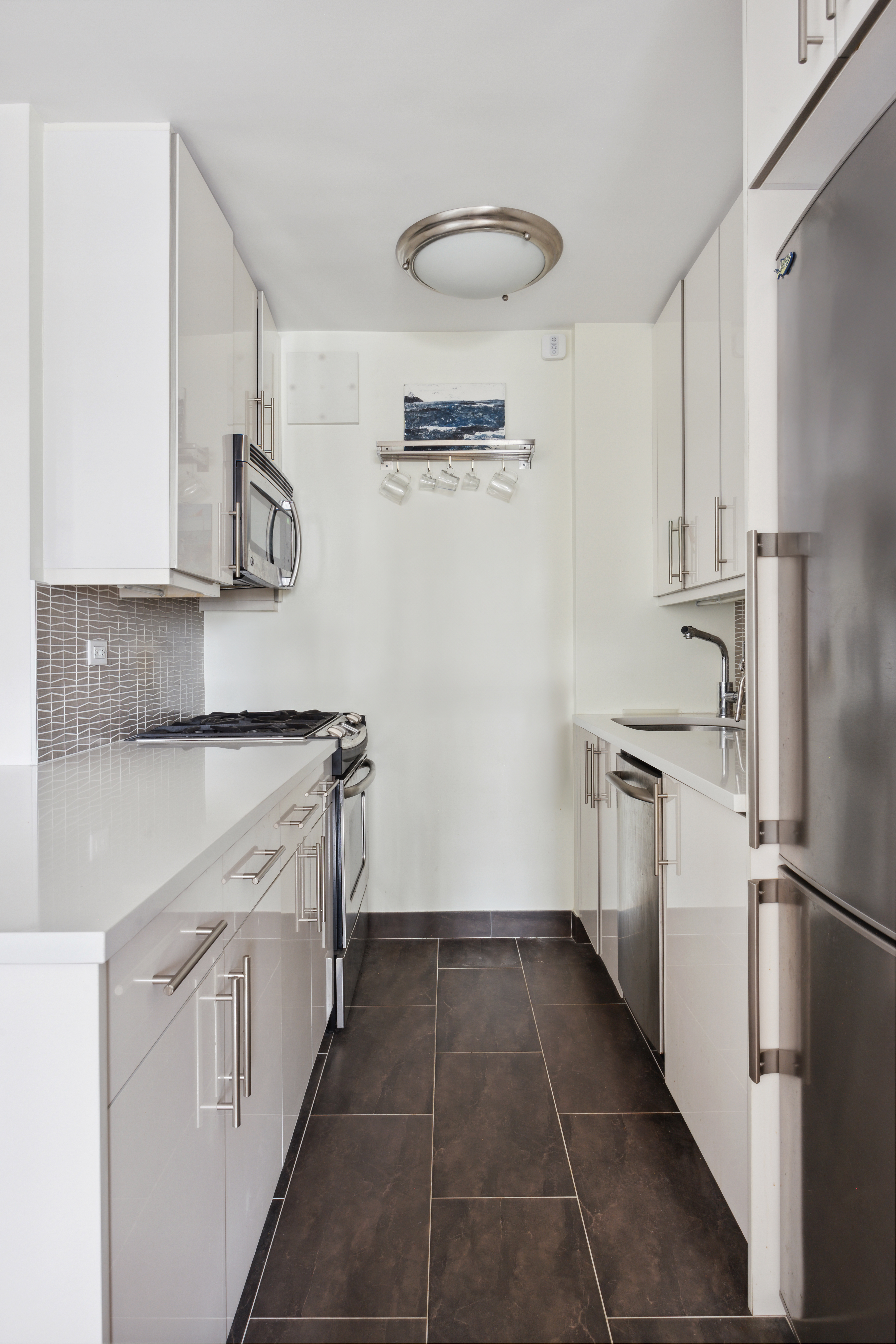 240 East 76th Street, Unit 14A Manhattan, NY 10021 - Photo 4 of 8 a kitchen with a refrigerator and a sink