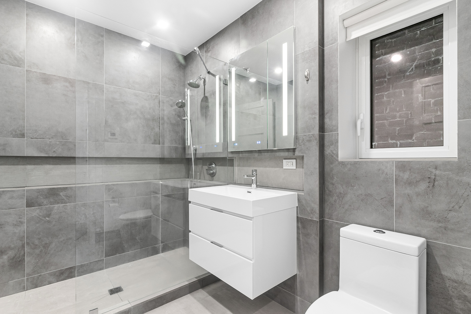 309 Ocean Parkway, Unit 4F Brooklyn, NY 11218 - Photo 5 of 14 a bathroom with a sink a toilet and shower