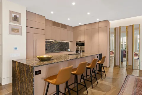a kitchen with stainless steel appliances granite countertop table chairs sink and cabinets