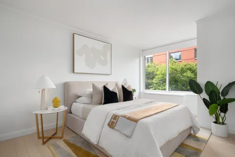 a bedroom with a bed and a potted plant