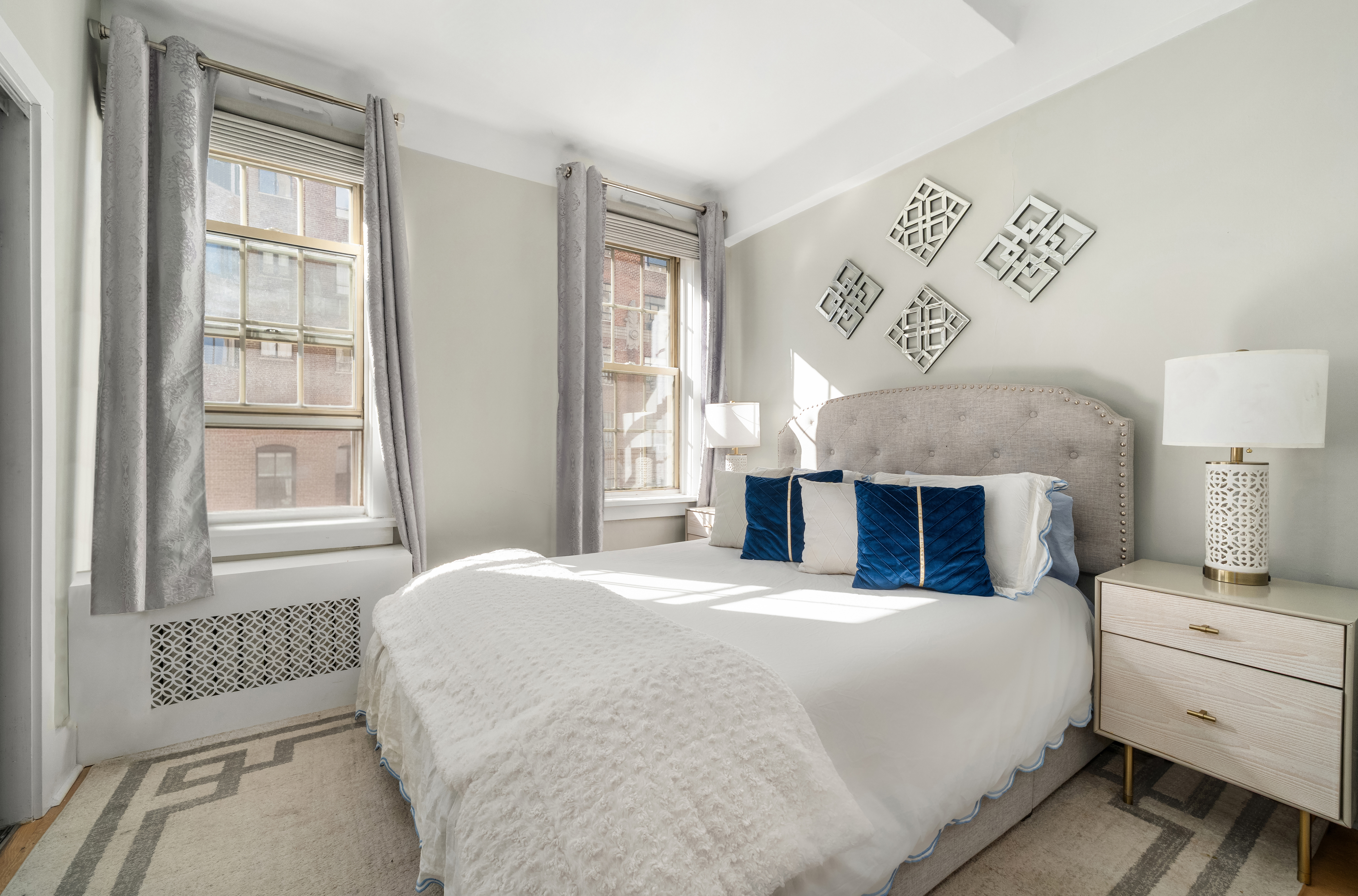 24 5th Avenue, Unit 1212 Manhattan, NY 10011 - Photo 3 of 9 a spacious bedroom with a large bed and a window