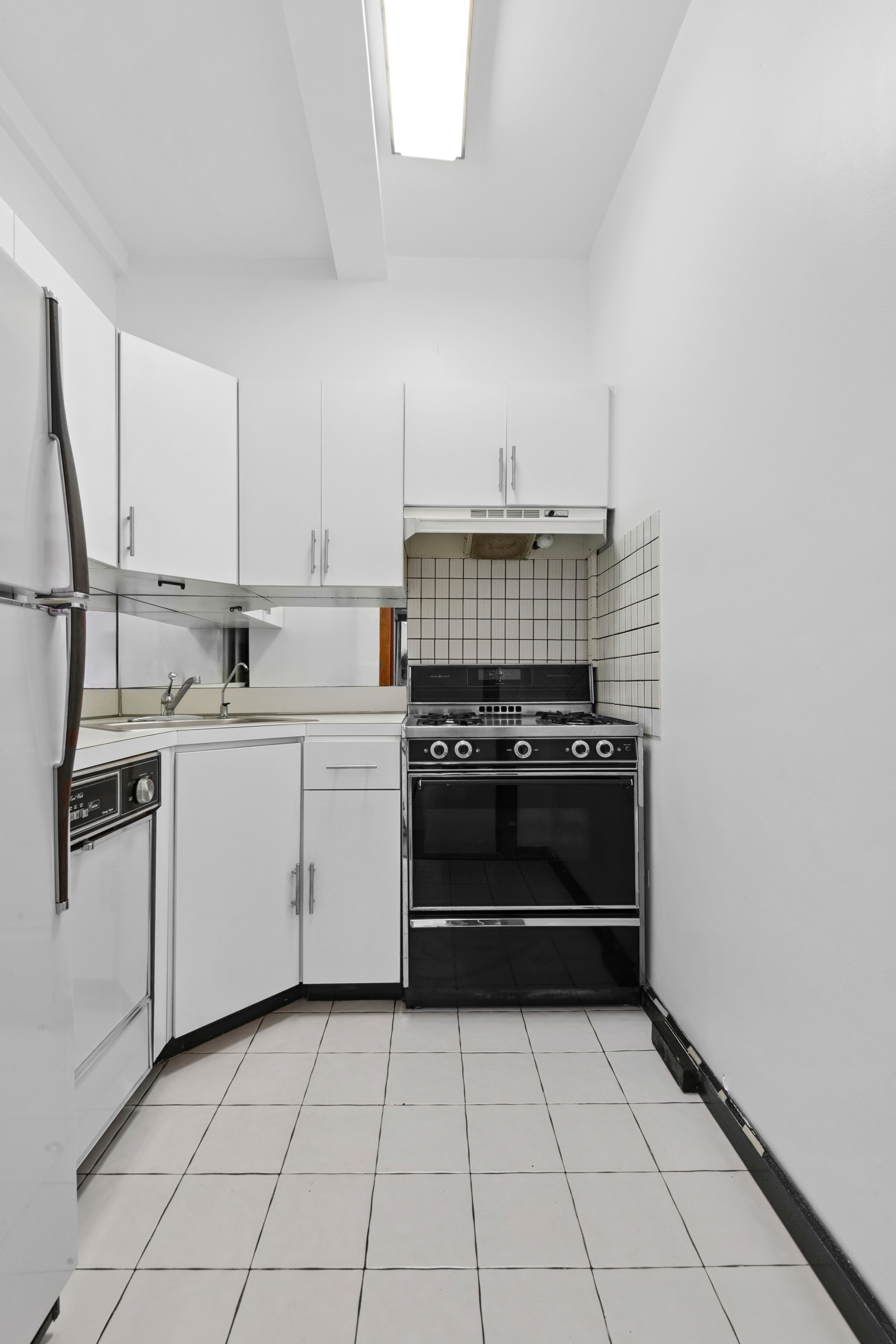 150 East 49th Street, Unit 9D Manhattan, NY 10017 - Photo 7 of 11 a kitchen with a stove and a sink