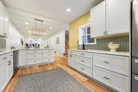 a large white kitchen with cabinets