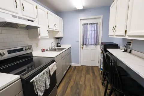 a kitchen with wooden cabinets stove and sink