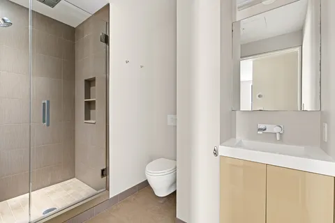 a bathroom with a sink a toilet and shower