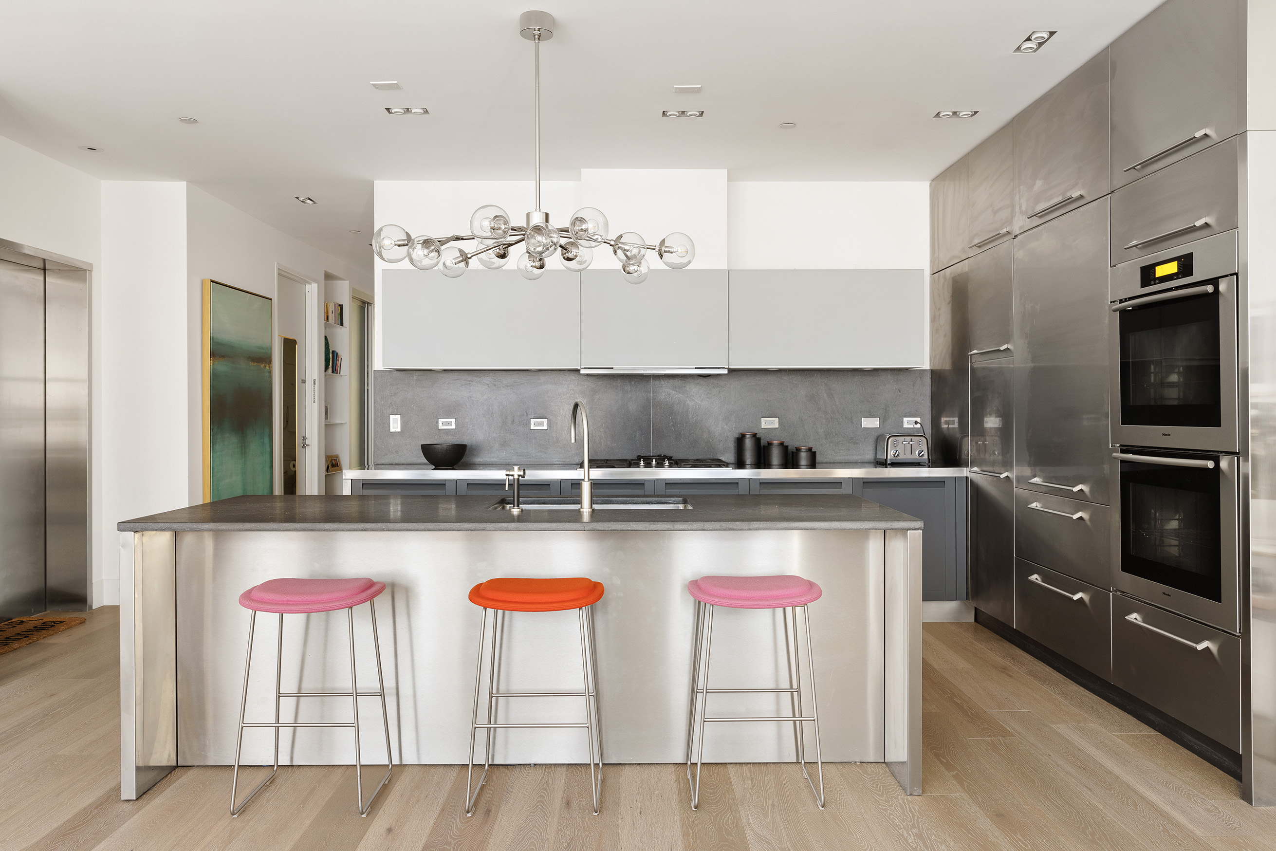51 Walker Street, Unit 4B Manhattan, NY 10013 - Photo 3 of 13 a kitchen with a stove a refrigerator and chairs