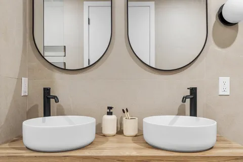 a bathroom with a sink a mirror and a a window