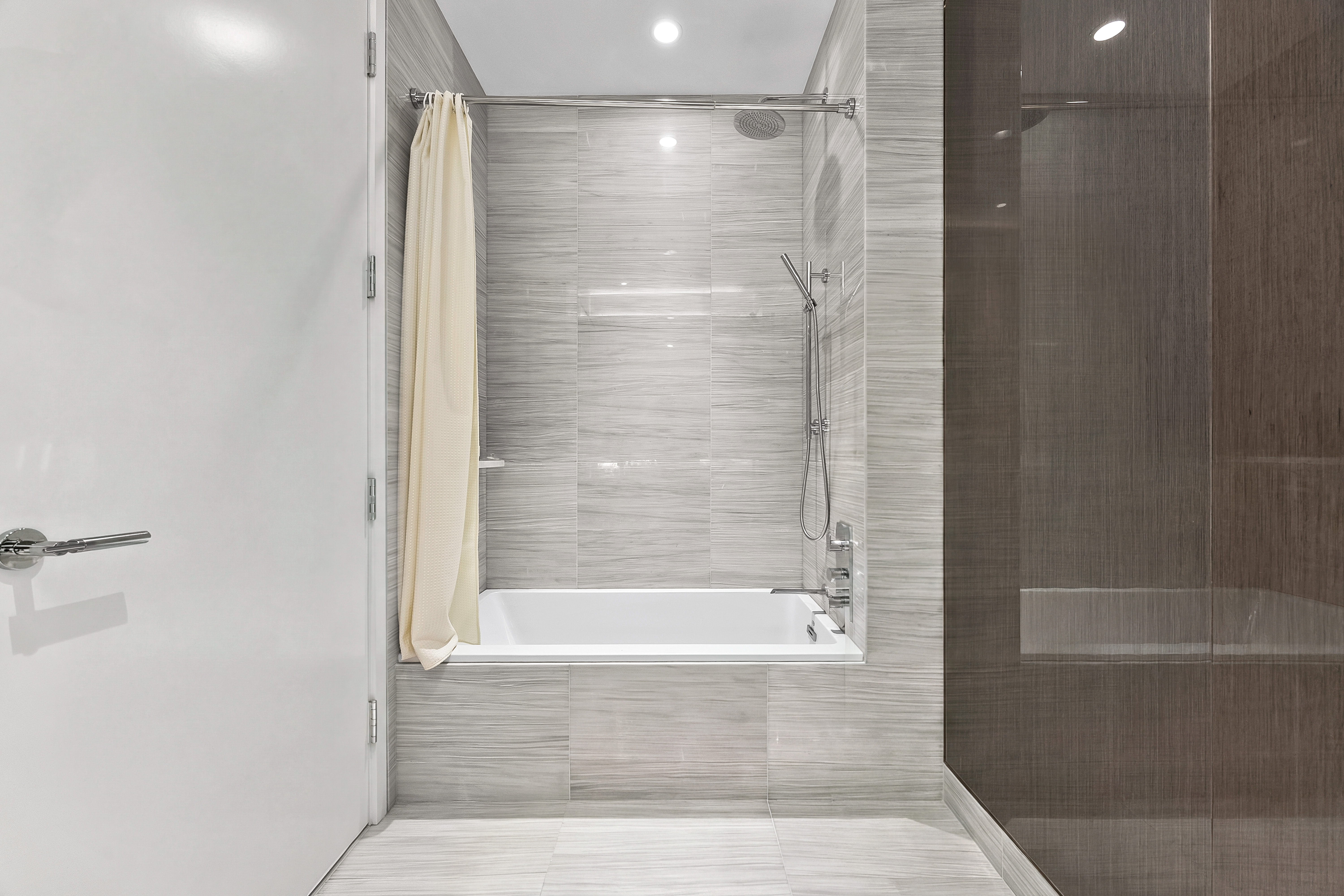 217 West 57th Street, Unit 36D Manhattan, NY 10019 - Photo 15 of 26 a bathroom with a shower and a bath tub