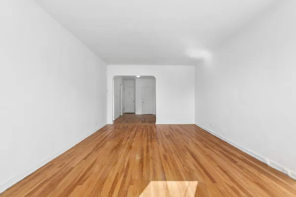 a view of a room with wooden floor and white walls