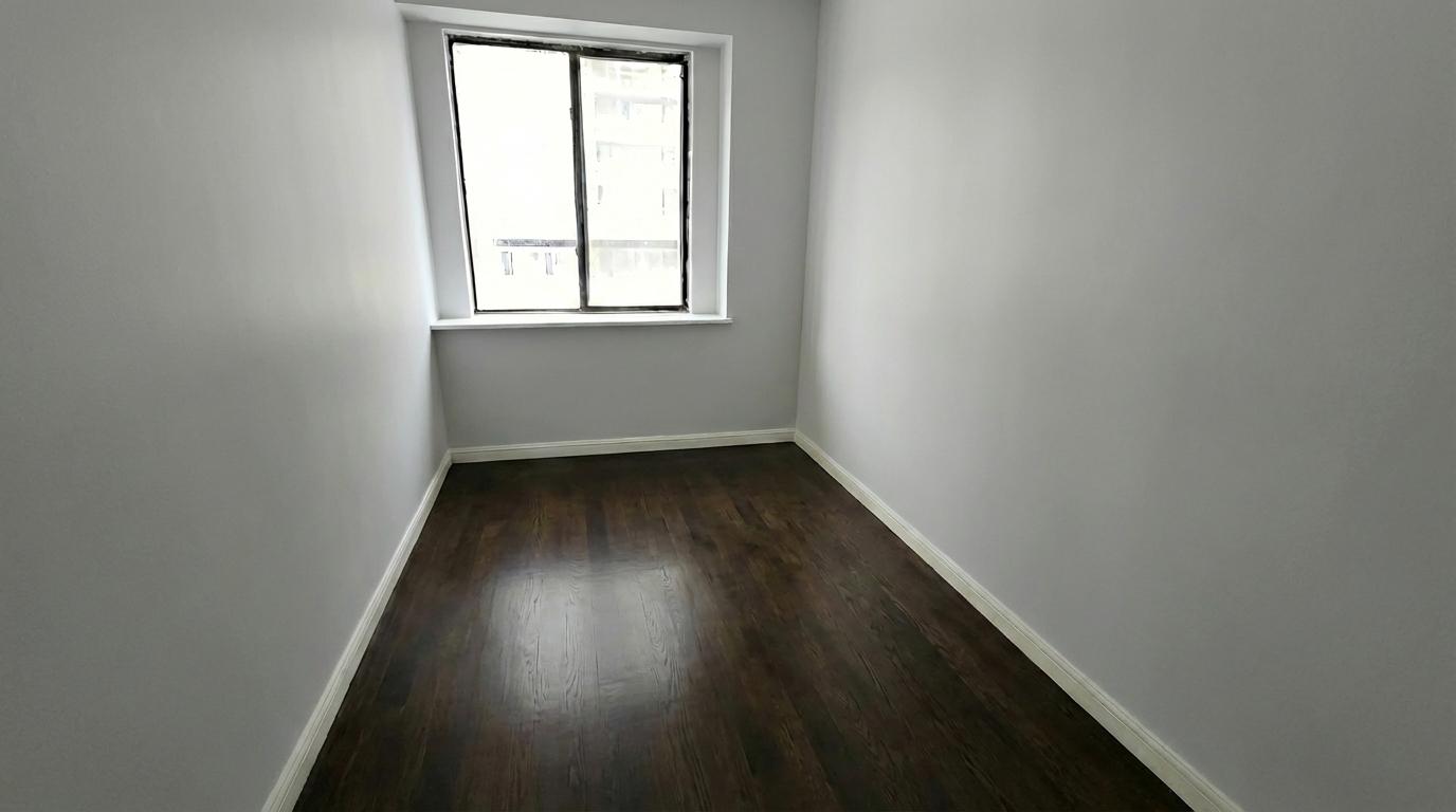 408 8th Avenue, Unit 5C Manhattan, NY 10001 - Photo 9 of 17 an empty room with wooden floor and windows