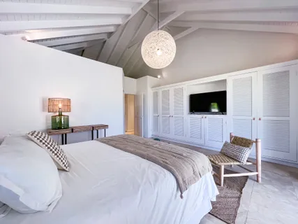 a spacious bedroom with a bed and a flat screen tv