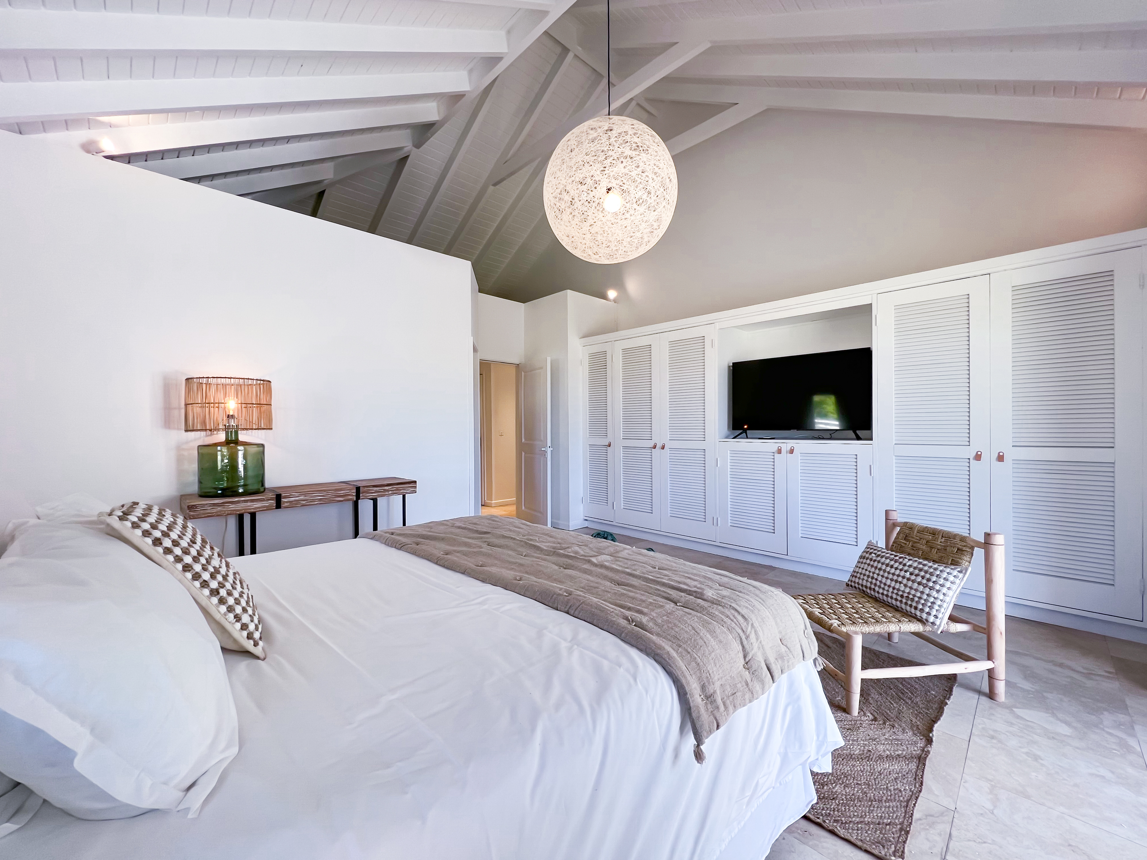 Terres Basses St. Martin, undefined 97150 - Photo 23 of 32 a spacious bedroom with a bed and a flat screen tv