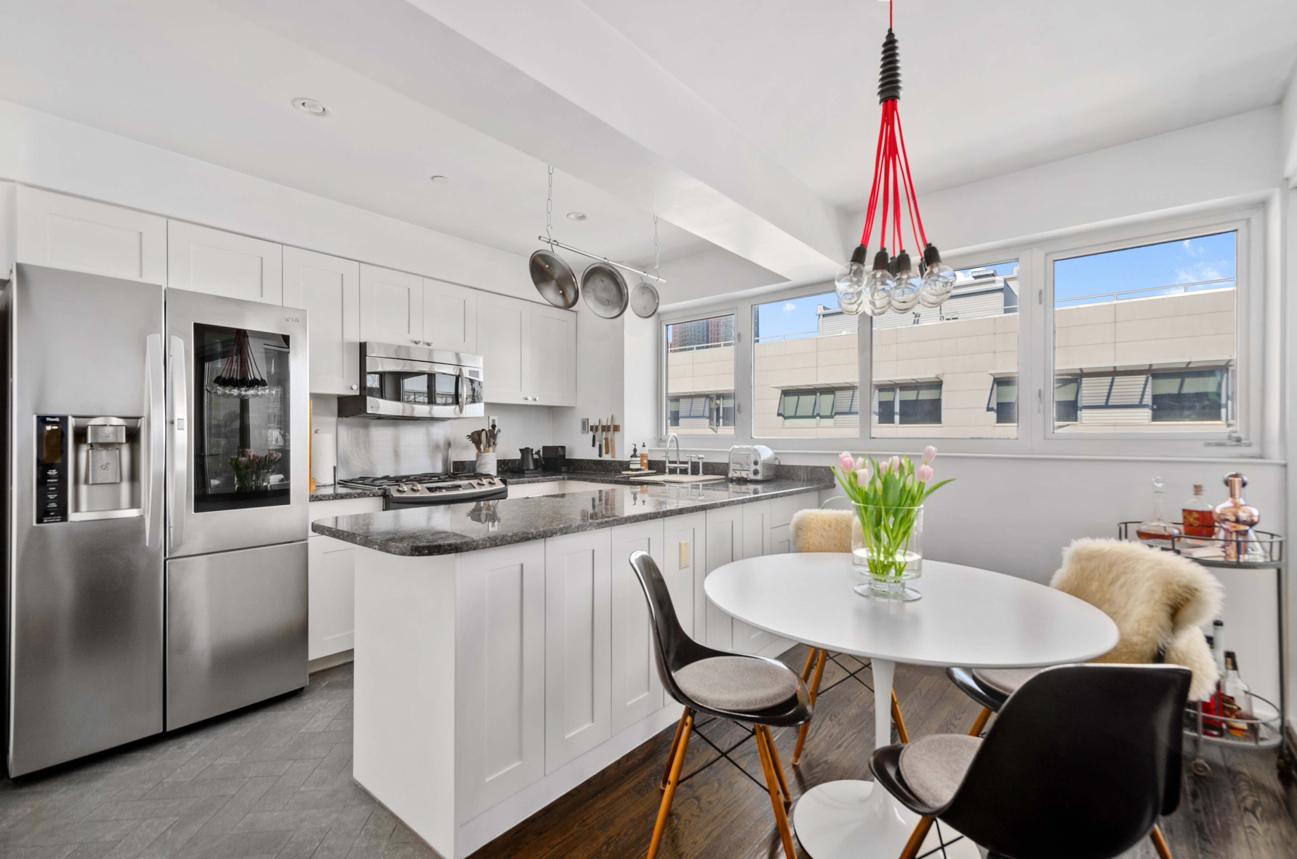 48 Box Street, Unit 4 Brooklyn, NY 11222 - Photo 2 of 9 a kitchen with stainless steel appliances kitchen island granite countertop a table chairs and white cabinets