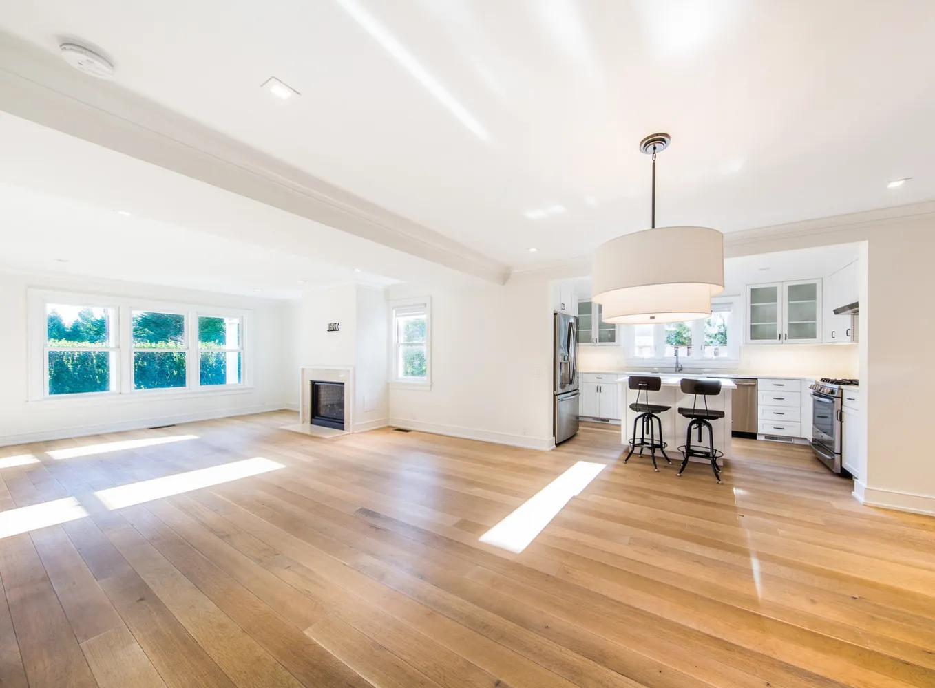 an empty room with windows and fireplace