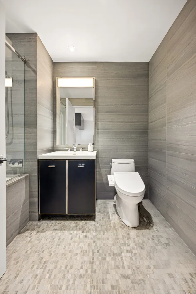 a bathroom with a toilet sink and mirror