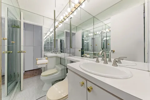 a bathroom with a double vanity sink toilet and shower