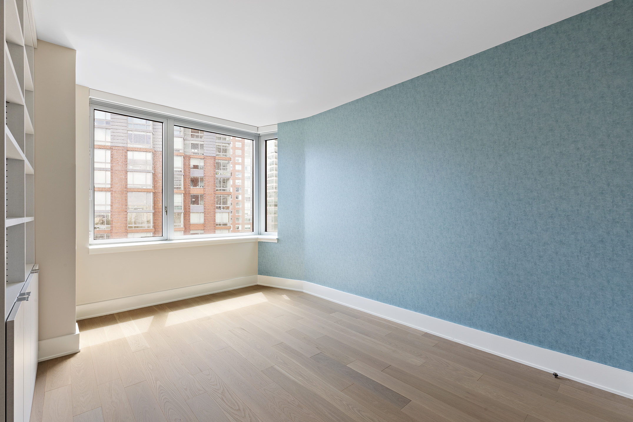 20 River Terrace, Unit 22A Manhattan, NY 10282 - Photo 6 of 27 an empty room with wooden floor and windows