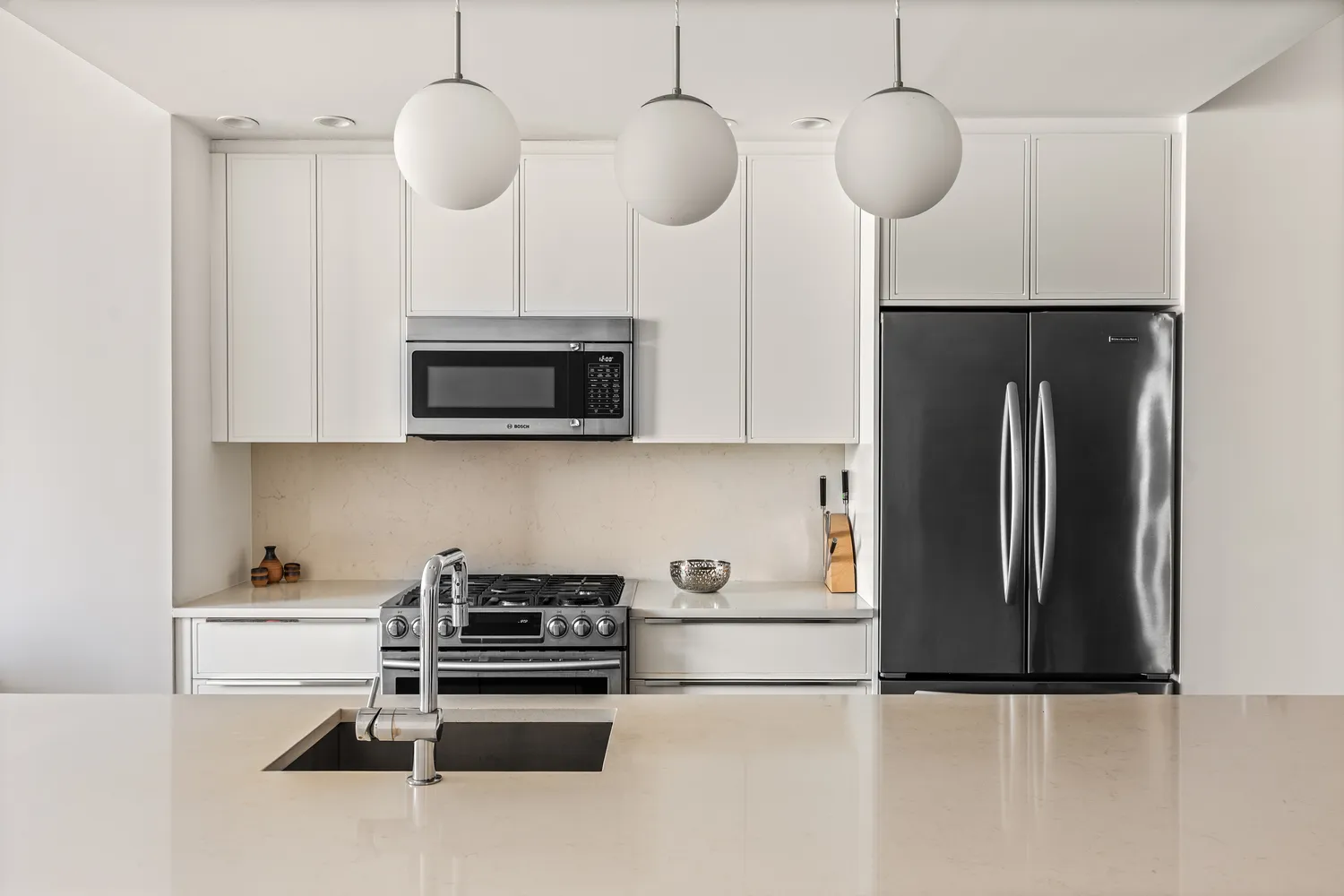 a kitchen with stainless steel appliances granite countertop a refrigerator a oven a sink and a microwave