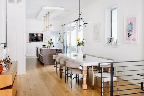 a view of a dining room and livingroom with furniture wooden floor a chandelier