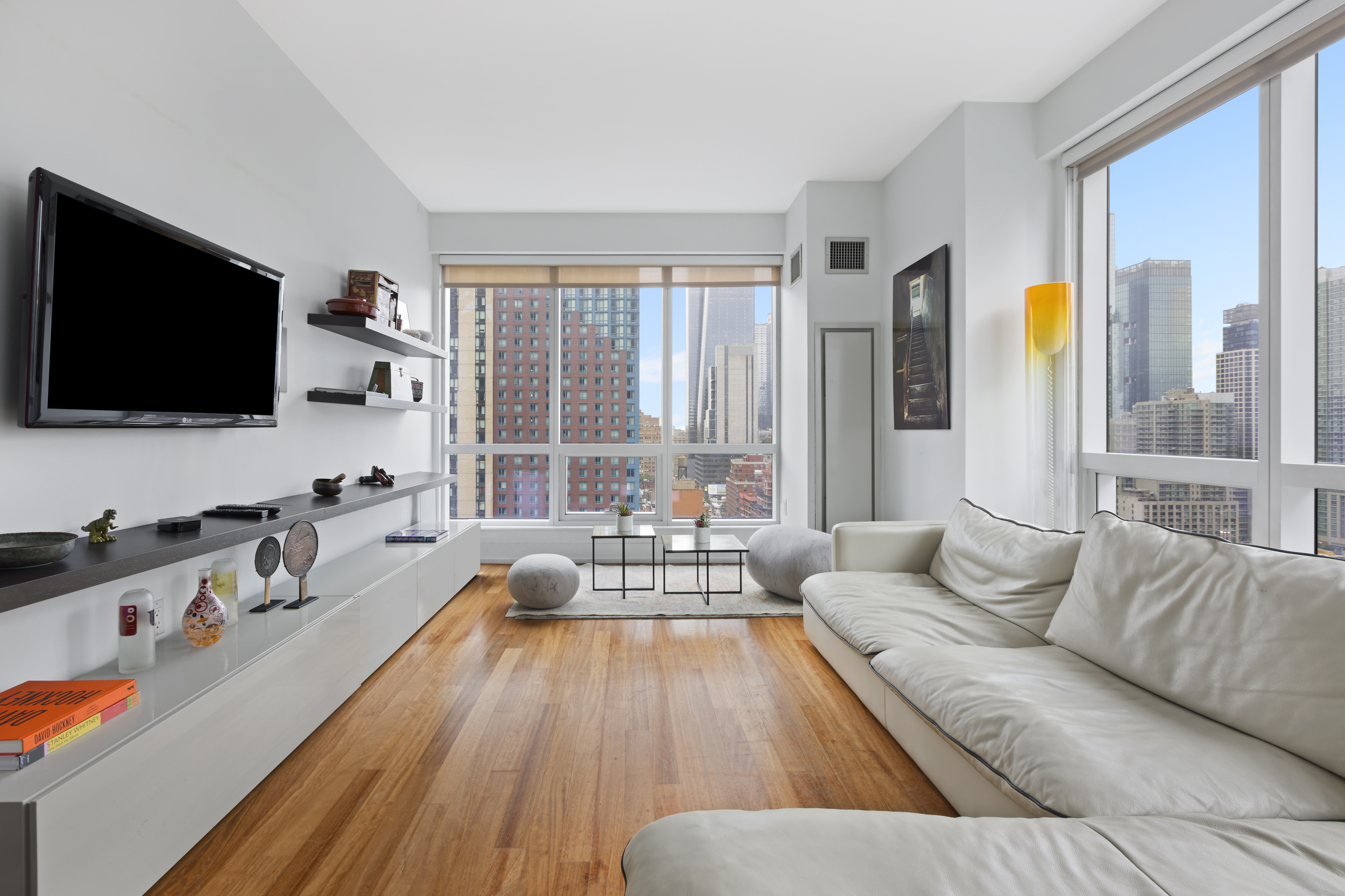 350 West 42nd Street, Unit 20L Manhattan, NY 10036 - Photo 4 of 11 a living room with furniture and a flat screen tv