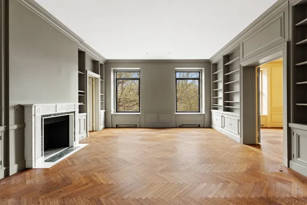 a view of an empty room with a fireplace and a window