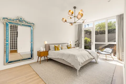 a bedroom with a bed and a chandelier