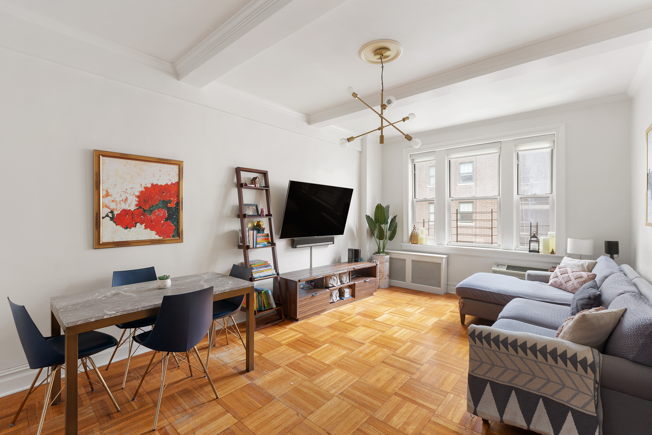 a living room with furniture a chandelier and a flat screen tv