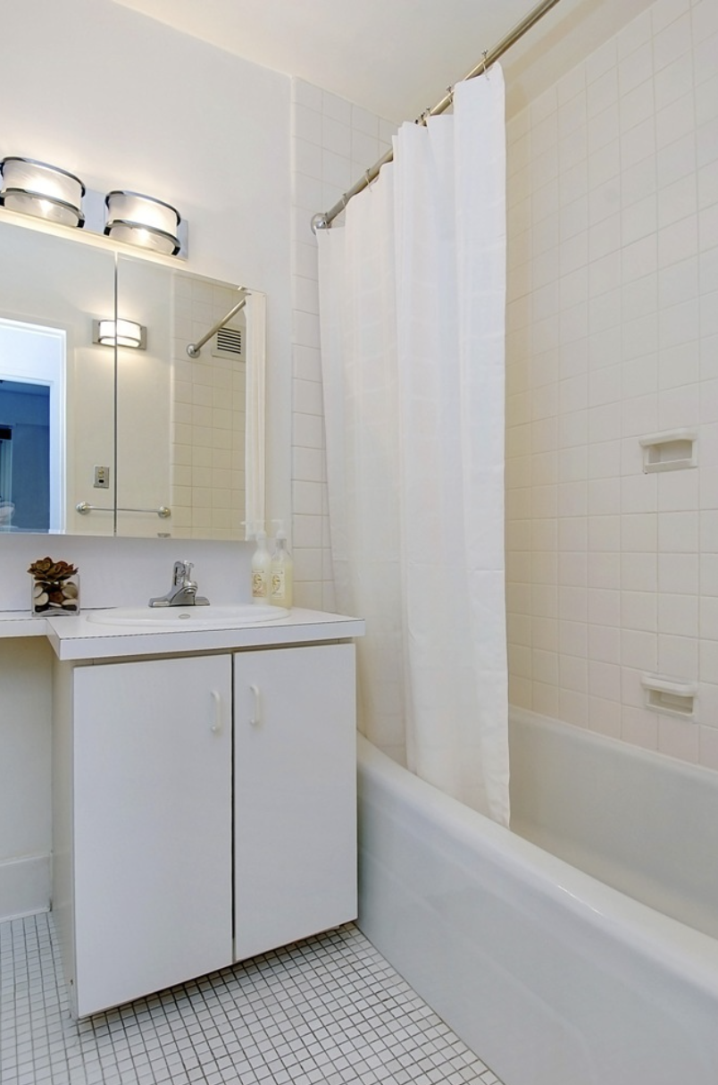 159 West 53rd Street, Unit 36C Manhattan, NY 10019 - Photo 5 of 9 a bathroom with a double vanity sink and a mirror