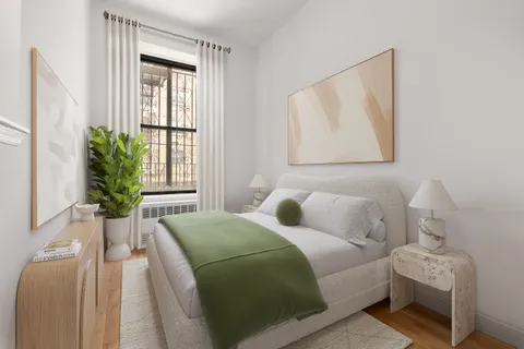 a bedroom with a bed and a potted plant